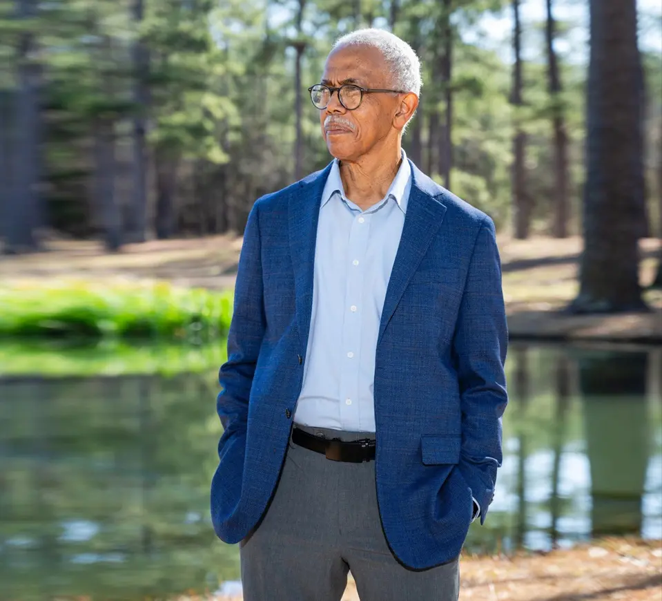 A man in a blue jacket standing next to water.